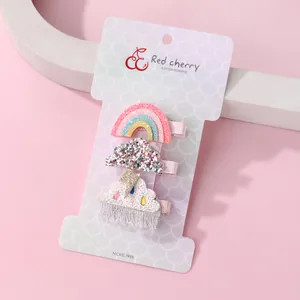 Détail de barrettes arc-en-ciel et nuages sur emballage sans nickel pour enfants