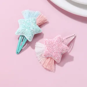 Detail of star-shaped children's hair clips with glitter sequins and colorful tassels