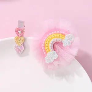 Pink heart and rainbow mesh hair clips set for girls on a white ceramic plate