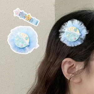 Dettaglio della molletta in tulle blu con paillettes e stelle glitterate per capelli