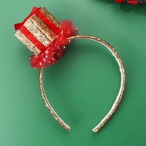 Close-up of golden sequin gift box headband with red ribbon and mesh for Christmas party