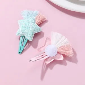 Close-up of glitter star hair clips with colorful tassels in mint green and pink