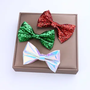 Détail de nœuds papillon pailletés rouge, vert et argent laser sur plateau brun