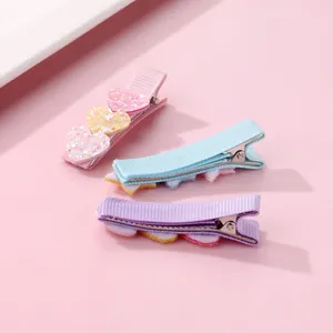 Three colorful glitter heart hair clips for girls featuring pink, blue, and purple ribbons