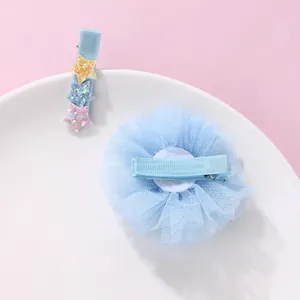 Dettaglio di fermagli per capelli con fiori in tulle blu e stelle di paillettes