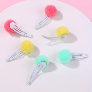 Détail de pinces à cheveux à pompons en tulle coloré et paillettes pour filles