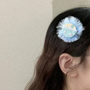 Dettaglio di molletta per capelli in tulle blu con paillettes a stella su capelli