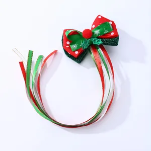 Détail d'une pince à cheveux de Noël avec nœud à flocons et rubans brillants suspendus
