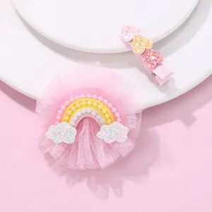 Detail of pink mesh rainbow hair clip and sequined heart pins on a white plate