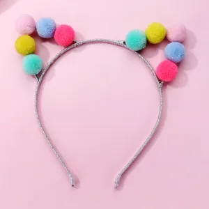 Detail showing colorful macaron plush balls on a glittery silver cat ear headband