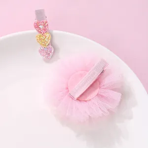 Set of mesh flower and glitter heart hair clips for girls on a white decorative plate