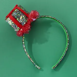 Detail of green glitter Christmas headband with red ribbon gift box and tulle floral decor
