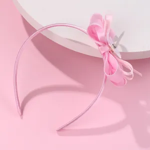 Sweet pink bow headband for girls with white flower detail and satin wrap finish