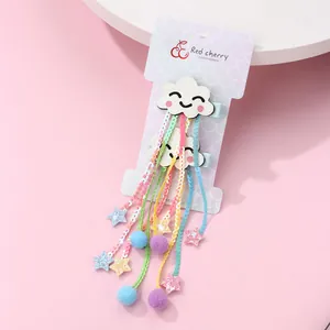 Détail de barrettes nuages pailletés avec glands en paillettes colorées et pompons