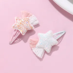 Detail of star-shaped snap hair clips with sparkling glitter and colorful soft tassels