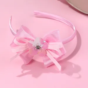 Detail of pink bow headband with sequins and a gemstone center for children
