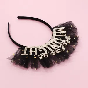 Detail of midnight kiss me glitter text and black mesh skirt with golden star sequins