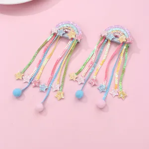 Detailed view of rainbow sequin hair clips with long tassels and glitter star accents