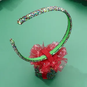 Close-up of sparkling green sequin headband with red tulle bow and matching gift box