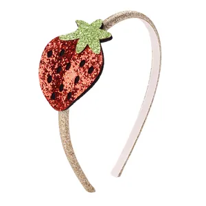 Sparkly gold strawberry headband for girls with red glitter fruit and green leaf detail