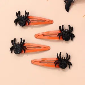 Détail de quatre barrettes à cheveux araignée orange pour Halloween avec paillettes noires