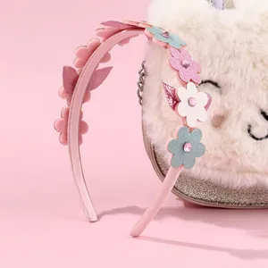 Gros plan sur un serre-tête pour filles orné de fleurs à paillettes et de faux diamants