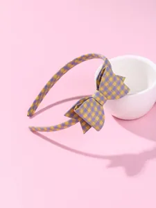 Detail of gingham checkered fabric headband with large yellow and purple bow ornament