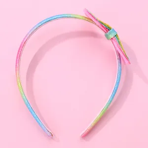 Close-up of rainbow glitter headband featuring a multi-layered fabric bow for girls