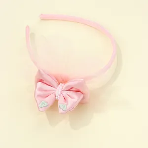 Dettaglio cerchietto rosa con fiocco ricamo a cuore e perle su tessuto in tulle