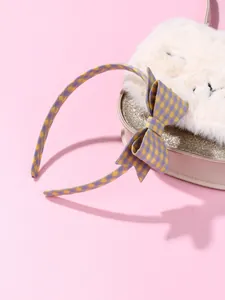 Detail of purple and yellow plaid fabric headband with a cute bow on a pink heart box
