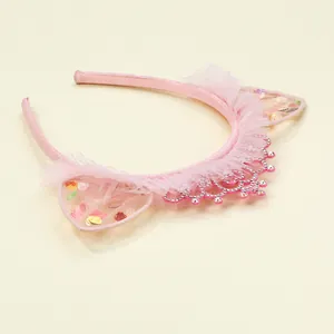 Dettaglio del cerchietto rosa con orecchie da gatto, paillettes, pizzo e corona di strass