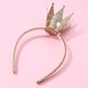 Golden glitter princess crown headband with hollow heart design on a pink background