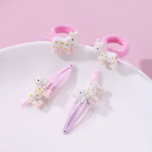 Pink unicorn hair clips and elastic hair ties set for kids displayed on a white plate
