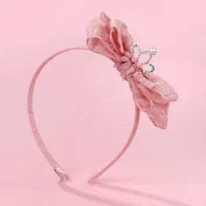 Detailed view of pink fabric headband featuring layered lace bow and crown with pearls