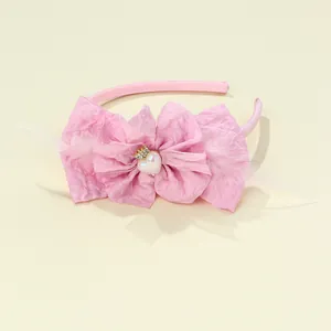 Pink handmade kids headband featuring a fabric bow with white feathers and crown
