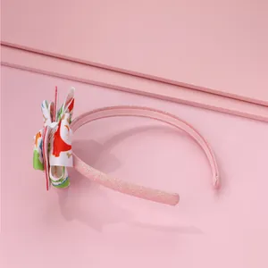 Dettaglio cerchietto rosa antiscivolo per bambine con fiocco a stampa dinosauro