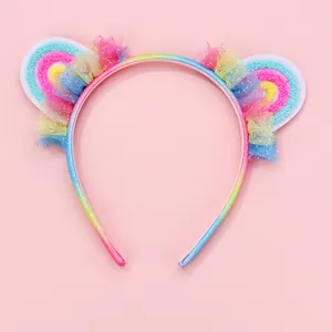 Détail de volants en tulle arc-en-ciel à paillettes sur un serre-tête oreilles de chat
