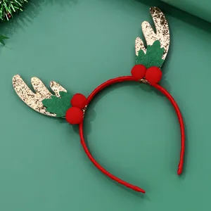 Detailed view of Christmas reindeer antler headband with sequins and festive red pom-poms
