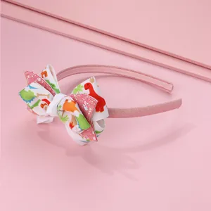 Dettaglio di cerchietto rosa per bimba con fiocco glitterato a dinosauro e antiscivolo