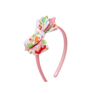 Cerchietto rosa per bambine con fiocco a strati glitterato e stampe di dinosauri