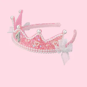 Détail de la couronne d'anniversaire rose à paillettes avec perles et dentelle