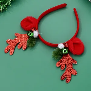 Detail of Christmas reindeer antler headband with red glitter, bells, and faux pine needles