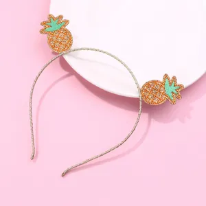 Sweet pineapple embroidered headband with gold glitter finish on a decorative ceramic plate