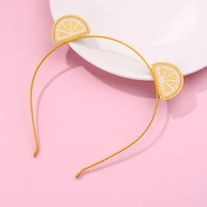 Yellow kids headband with sweet lemon embroidery and cat-ear design on pink background