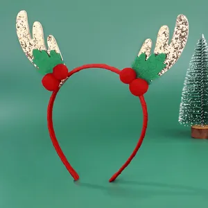 Christmas reindeer antler headband with gold sequins and red pom-poms on green backdrop