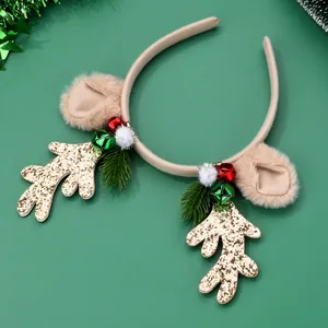 Detail of Christmas reindeer antler headband with golden glitter, bells and green foliage