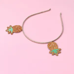 Detail of children's non-slip headband featuring two sparkling sequin pineapple decorations