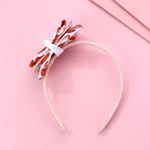 Détail du serre-tête rose scintillant avec un nœud blanc orné de motifs de basket-ball