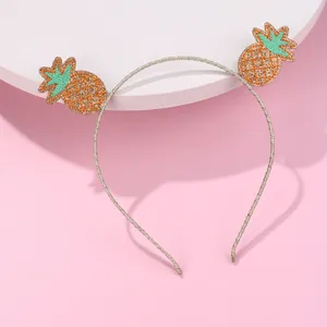 Close-up of glittery pineapple hair hoop with sequins on a pink background base