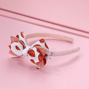 Détail d'un serre-tête pailleté rose avec nœud côtelé et motif de basket-ball